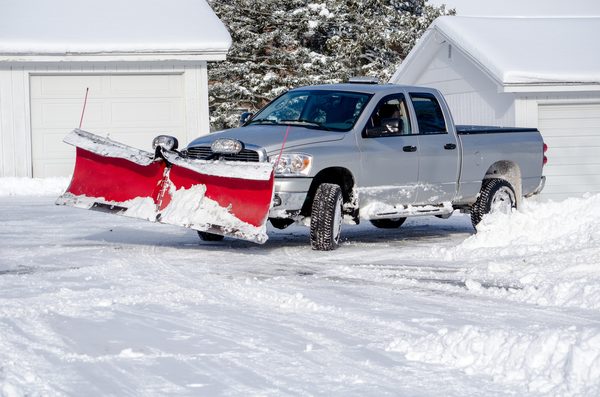 Residential snow removal — plow truck clearing a driveway